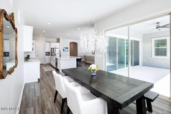 dining area featuring a ceiling fan, recessed lighting, wood finished floors, and arched walkways