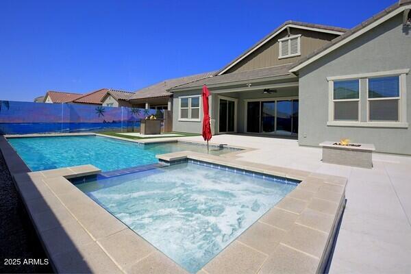 view of pool featuring a fenced in pool, ceiling fan, fence, a patio area, and an in ground hot tub