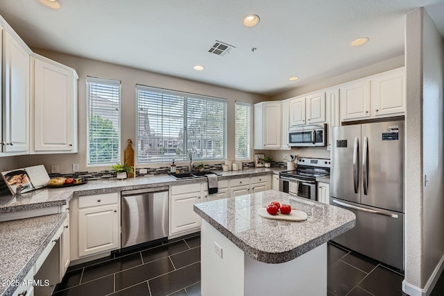 kitchen featuring a sink, visible vents, dark tile patterned flooring, and appliances with stainless steel finishes