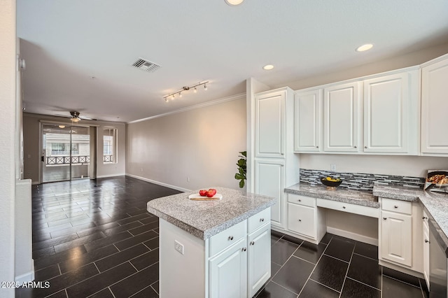 kitchen with visible vents, open floor plan, a center island, and white cabinetry