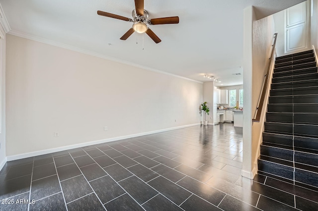 unfurnished living room with stairs, crown molding, a ceiling fan, and baseboards