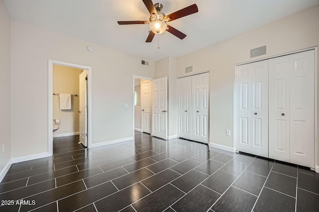 unfurnished bedroom with visible vents, multiple closets, baseboards, and ensuite bath