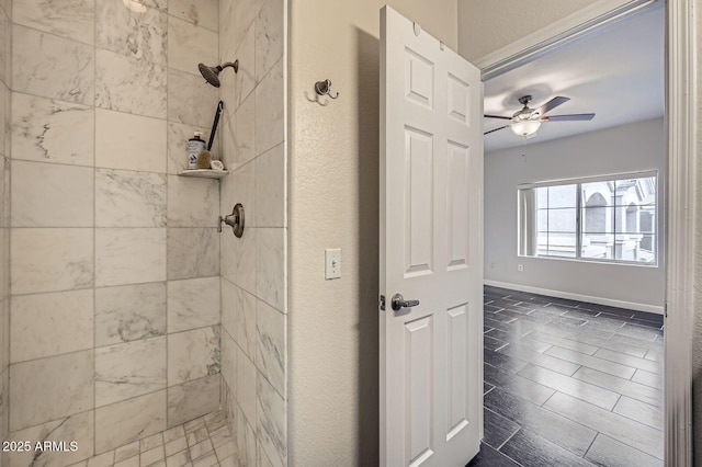 full bathroom featuring baseboards, tiled shower, ceiling fan, and a textured wall