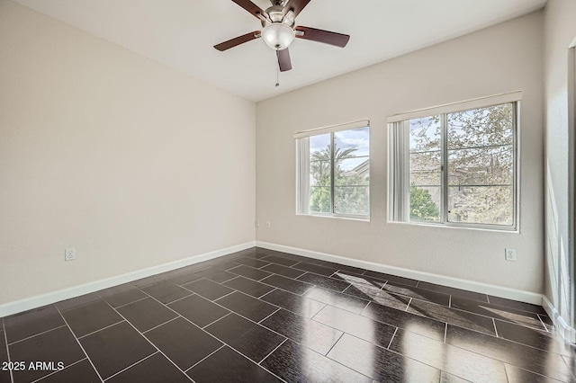 spare room featuring baseboards and a ceiling fan