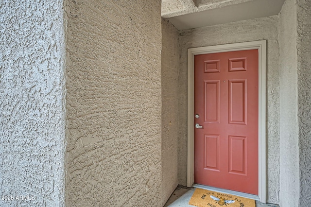 entrance to property featuring stucco siding