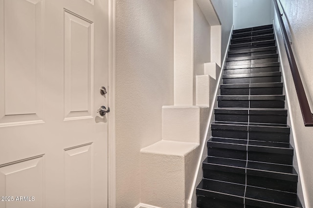 staircase featuring a textured wall