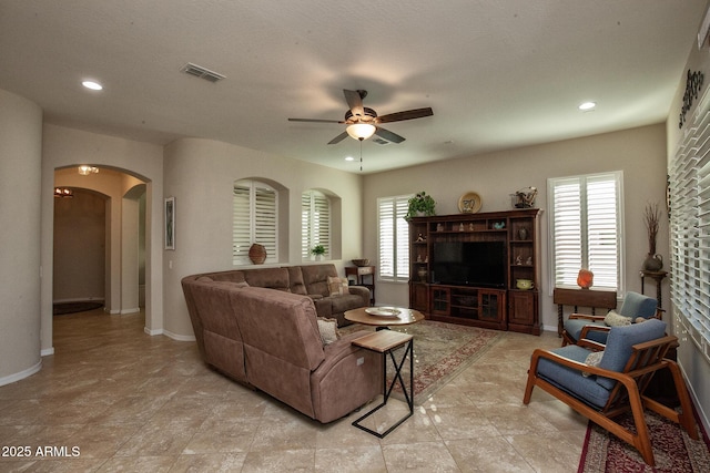 living room featuring ceiling fan and a wealth of natural light