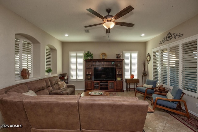 tiled living room with ceiling fan and a wealth of natural light