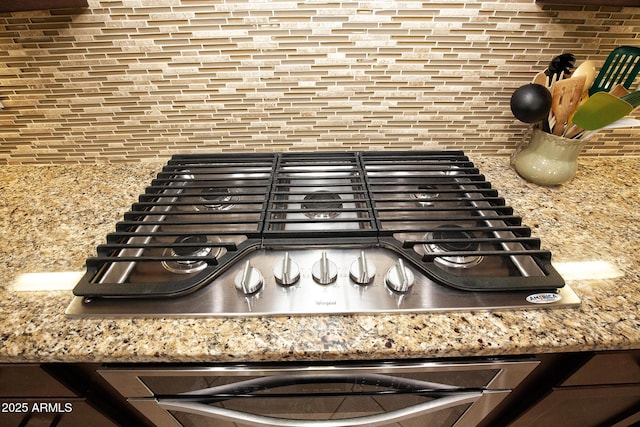 room details with stainless steel gas stovetop and light stone counters