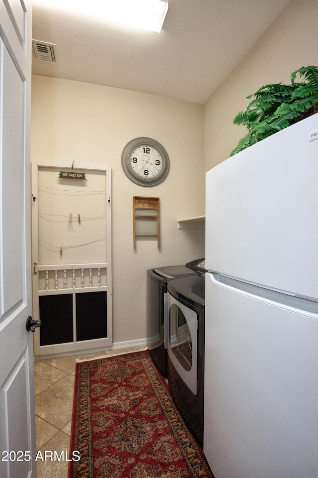 laundry room featuring tile patterned flooring and separate washer and dryer