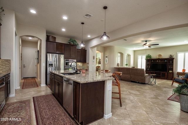 kitchen featuring ceiling fan, sink, stainless steel appliances, decorative light fixtures, and decorative backsplash