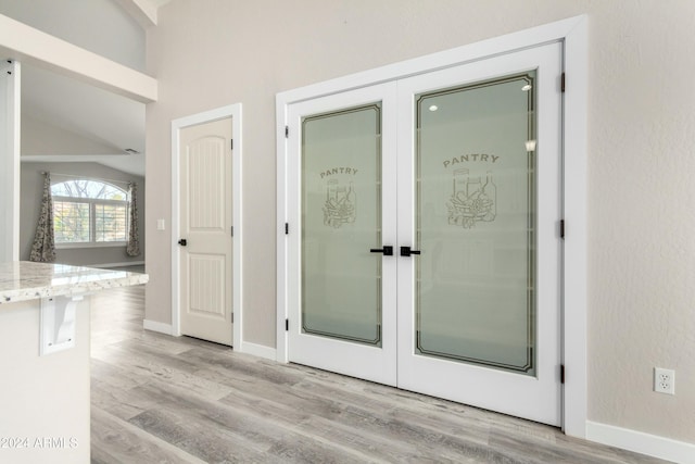 interior space with light hardwood / wood-style flooring, french doors, and lofted ceiling