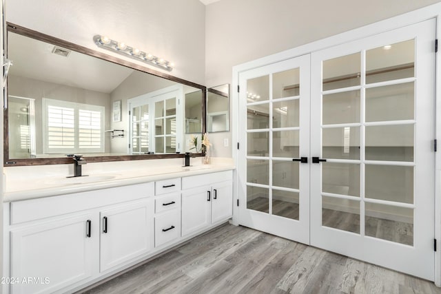 bathroom featuring lofted ceiling, french doors, vanity, and hardwood / wood-style floors