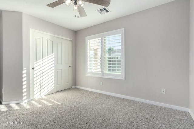 unfurnished bedroom featuring ceiling fan, a closet, and carpet