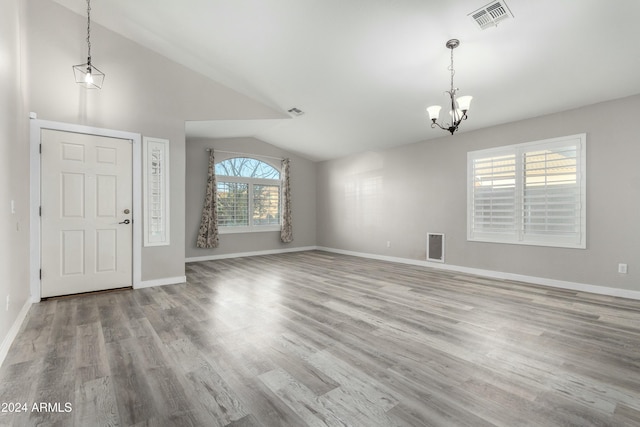 entrance foyer featuring light hardwood / wood-style floors, vaulted ceiling, and a notable chandelier