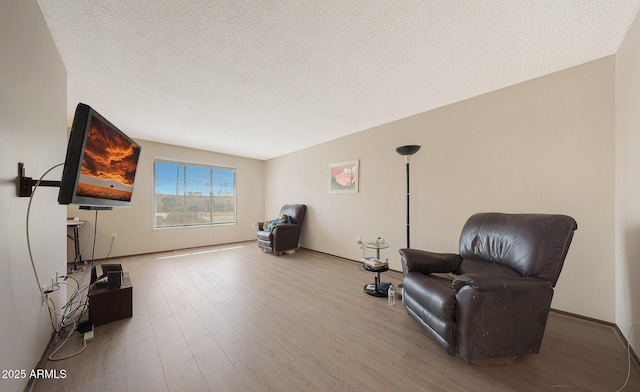 living area with a textured ceiling and wood finished floors