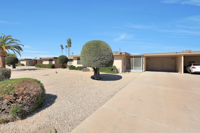 view of front of property with an attached carport, concrete driveway, and stucco siding