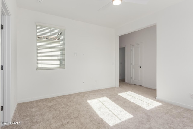 unfurnished room featuring baseboards, a ceiling fan, and light colored carpet