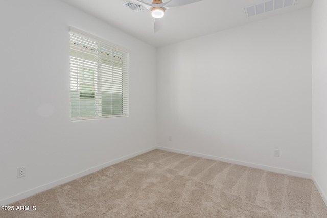 carpeted spare room with ceiling fan, visible vents, and baseboards