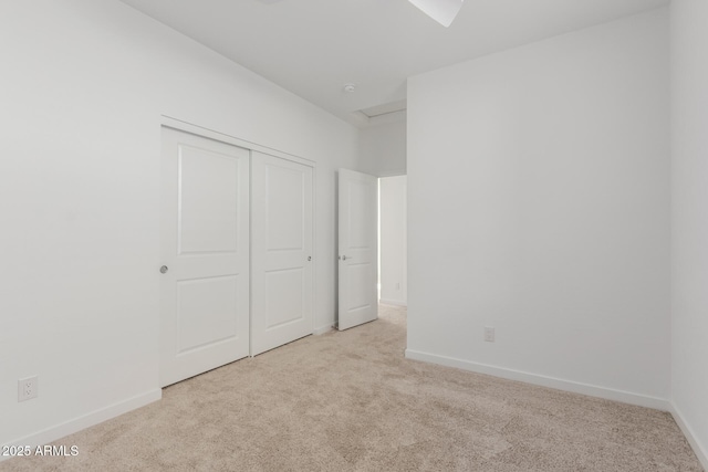 unfurnished bedroom with carpet floors, a closet, and baseboards