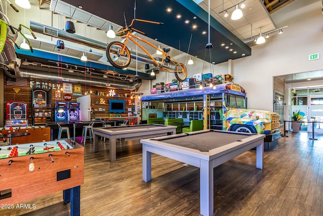 game room featuring pool table, wood finished floors, a towering ceiling, and track lighting