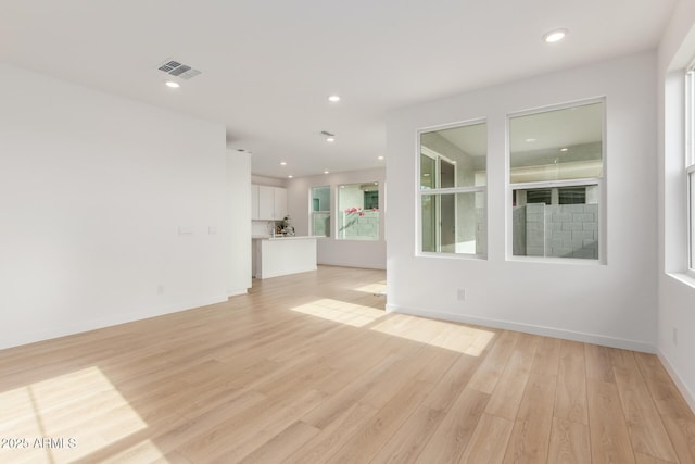 unfurnished living room with light wood-type flooring, visible vents, and recessed lighting