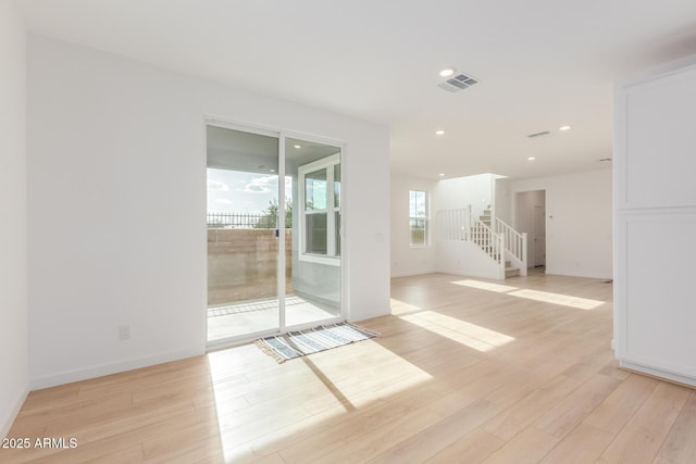 unfurnished room with recessed lighting, visible vents, baseboards, stairs, and light wood finished floors