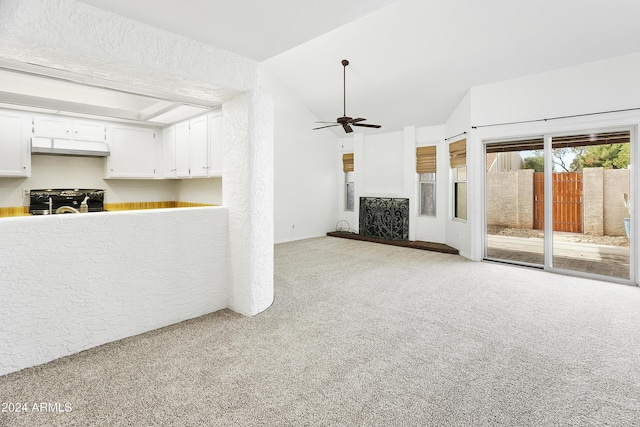 unfurnished living room with light carpet, ceiling fan, and vaulted ceiling