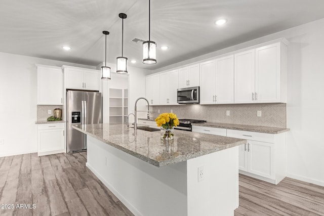 kitchen featuring white cabinets, an island with sink, and appliances with stainless steel finishes