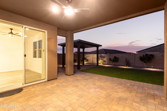 patio terrace at dusk featuring ceiling fan