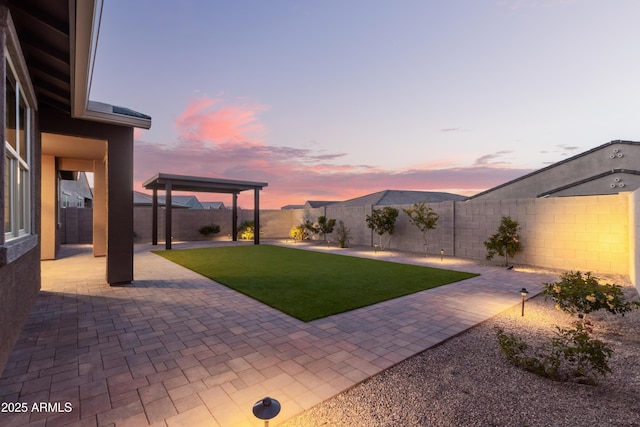 yard at dusk featuring a patio area