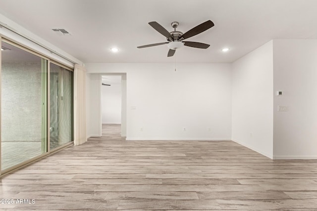 spare room featuring light wood-type flooring, ceiling fan, and a healthy amount of sunlight