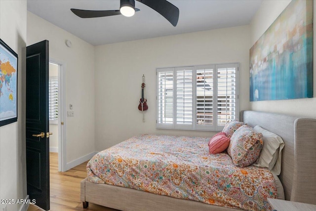 bedroom featuring wood finished floors, baseboards, and ceiling fan