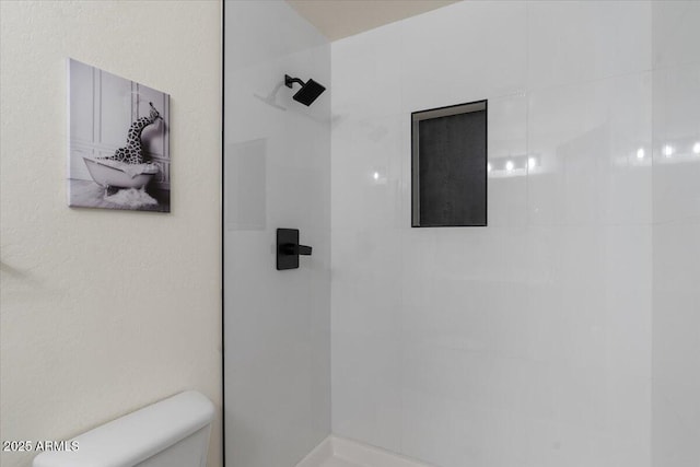 full bath featuring toilet and a tile shower