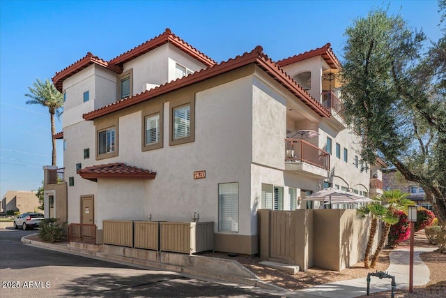 exterior space featuring stucco siding and a tiled roof