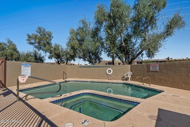 view of swimming pool with a hot tub