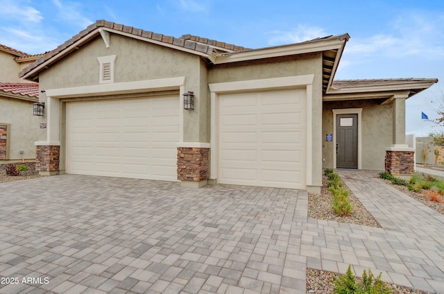 19420 W San Juan Ave, Litchfield Park, AZ 85340 - view of front of house featuring an attached garage, stucco siding, and decorative driveway