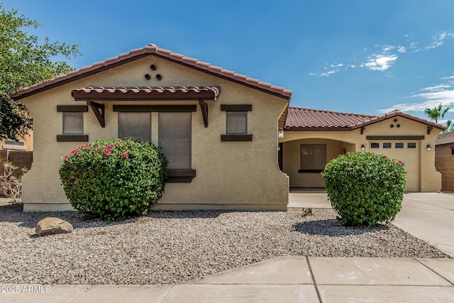 6826 W St Charles Ave, Laveen, AZ 85339 - mediterranean / spanish home featuring an attached garage, a tile roof, stucco siding, and driveway