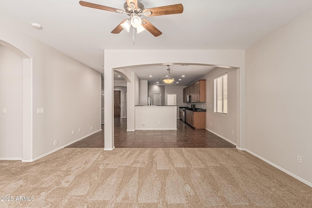6826 W St Charles Ave, Laveen, AZ 85339 - unfurnished living room featuring dark carpet, arched walkways, and ceiling fan