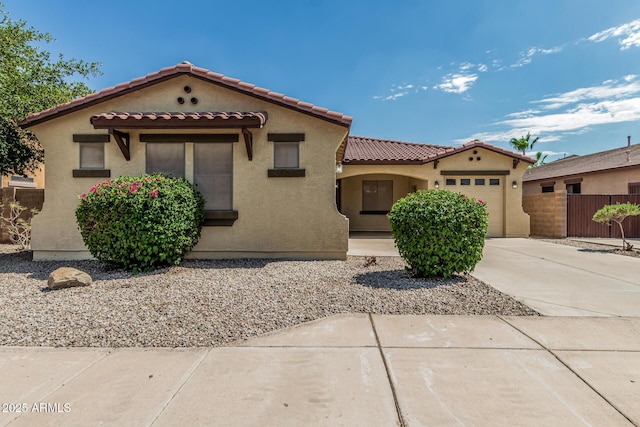 6826 W St Charles Ave, Laveen, AZ 85339 - mediterranean / spanish house with driveway, an attached garage, a tiled roof, and stucco siding