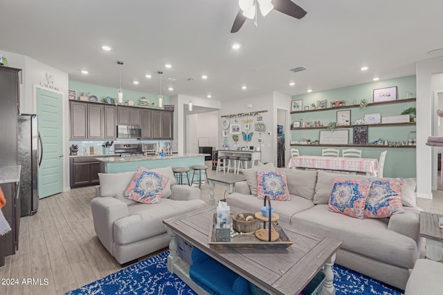 living room with light wood-type flooring and ceiling fan