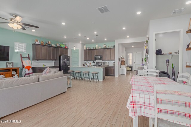 living room featuring light wood-type flooring and ceiling fan