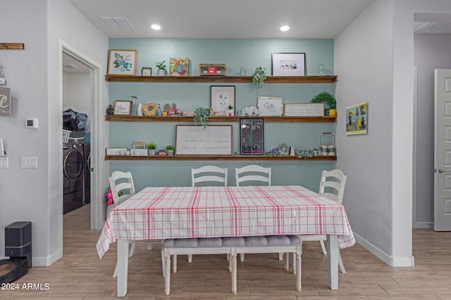 dining area with washer and dryer and light hardwood / wood-style flooring