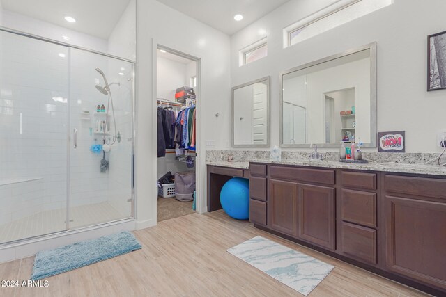 bathroom featuring a shower with door, vanity, and hardwood / wood-style flooring