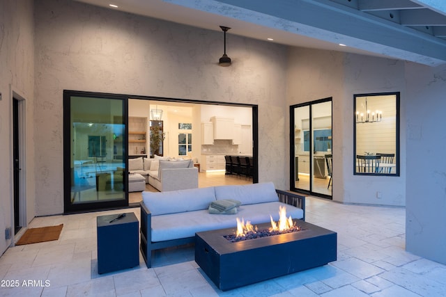 view of patio with an outdoor living space with a fire pit