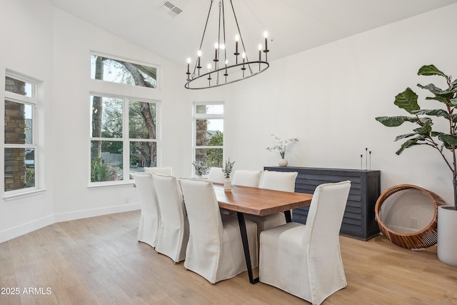 dining area featuring high vaulted ceiling and light hardwood / wood-style flooring