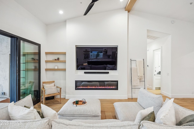 living room with vaulted ceiling with beams and light hardwood / wood-style flooring