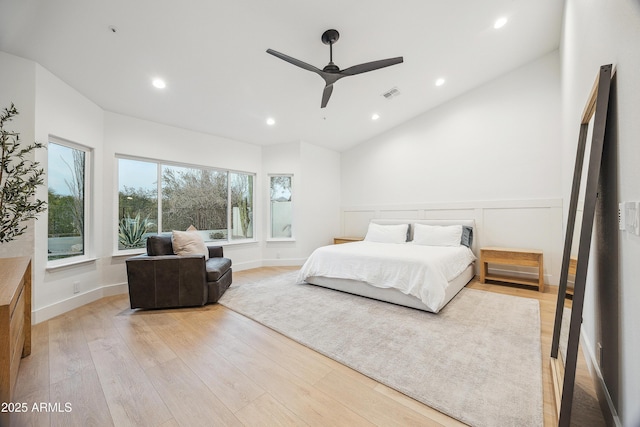 bedroom with ceiling fan, lofted ceiling, and light hardwood / wood-style flooring