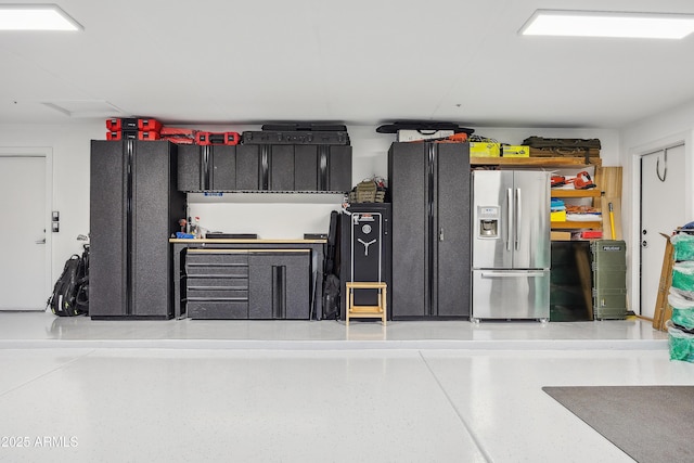 garage featuring stainless steel fridge with ice dispenser