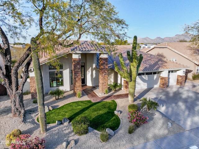 view of front facade with a garage, a mountain view, and a front lawn